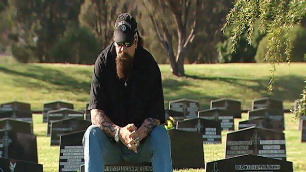 Geoff "Snake" Campbell, a former member of the Bandidos bikie gang, sits on the grave stone of one of his brothers - two of which died at Milperra in the Father's Day massacre. 