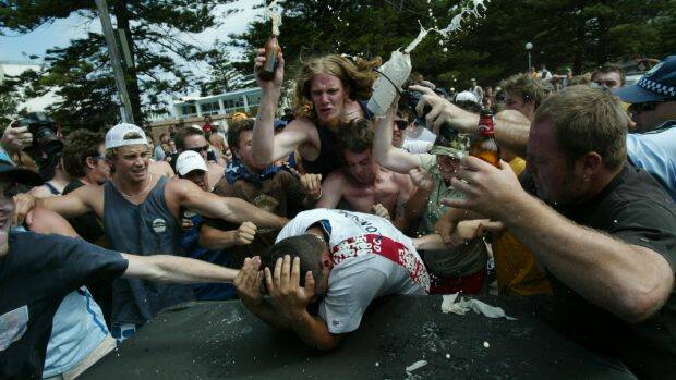 Geoffrey Atkinson, wearing a green shirt and camouflage cap, joins the mob of men attacking Safi Merhi during the Cronulla riots. Photo: Andrew Meares