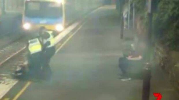 PSOs dragging the woman to safety.  Photo: Channel 7