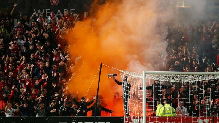 A flare is lit amongst Wanderers fans during the match between the Wanderers and Perth Glory. Photo: Brendon Thorne