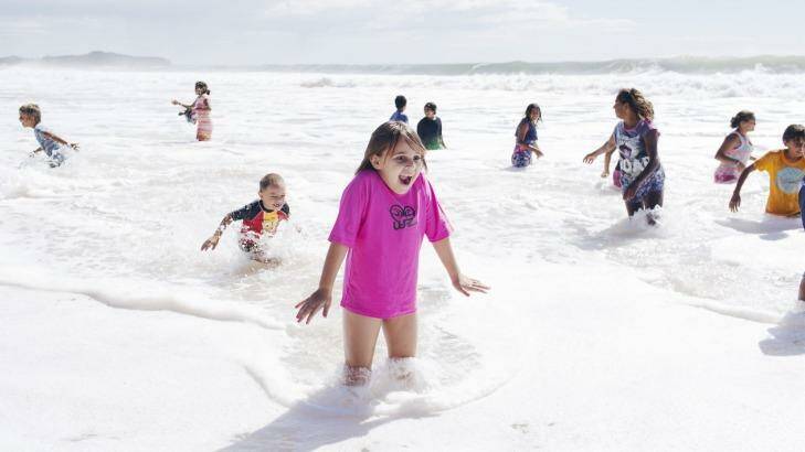 Foamy frolic: children from Brewarrina in rural NSW take to the waves at Narrabeen. Photo: James Brickwood