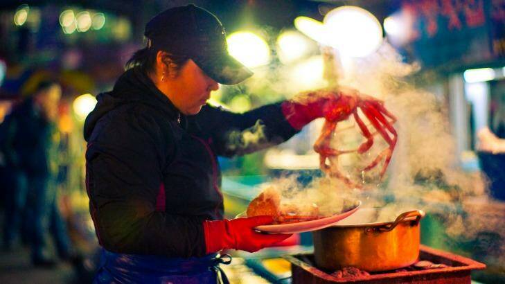 A vendor prepares freshly steamed crab at an outdoor market in South Korea. Photo: Flash Parker