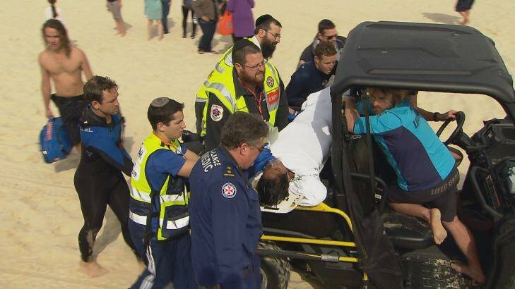 A student is treated by lifeguards and paramedics at Bondi Beach. Photo: Daniel Shaw