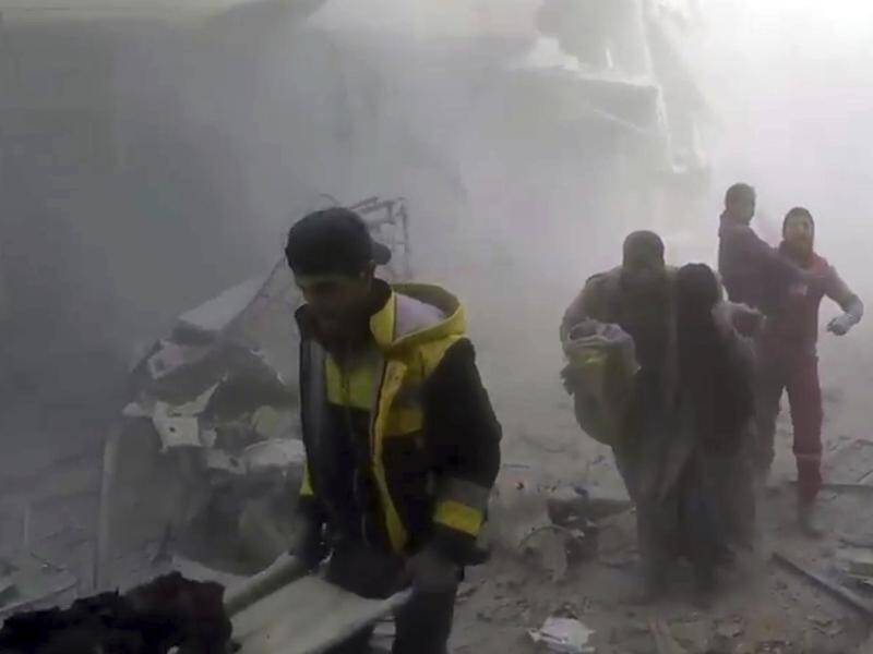 Members of Syria's White Helmets rescue group help residents during airstrikes in eastern Ghouta.