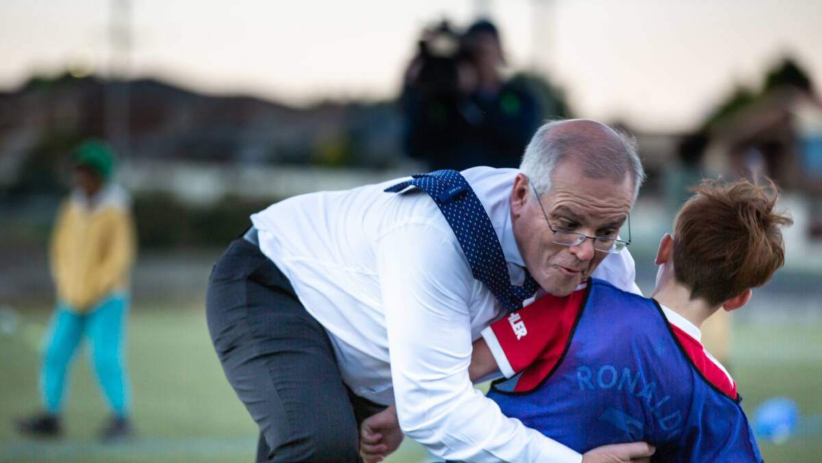 Prime Minister Scott Morrison crash tackles Striker's Luca Fauvette at the Devonport Soccer Club during the 2022 election campaign. Picture by Eve Woodhouse 