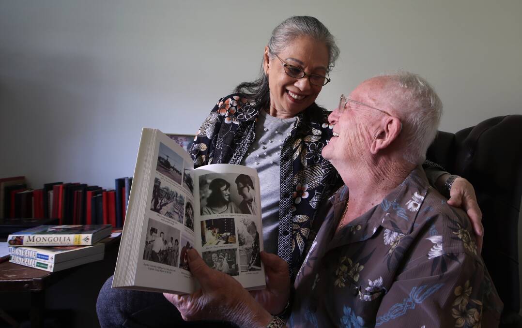 Kim Dung and Carl Robinson share a laugh over their photo in the book The Bite of the Lotus. Photo: Sylvia Liber