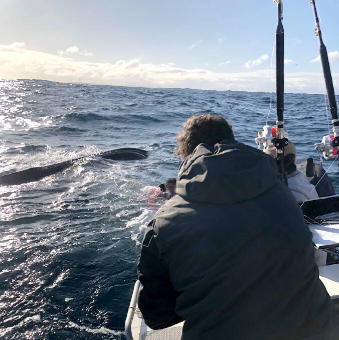JUST IN TIME: Anglers Conor and Nicky Edwards and Luke Goldstein approaching an upturned jet ski and rider, top left, about six kilometres off Portland. The fishers saved the man last week. Picture: Supplied.