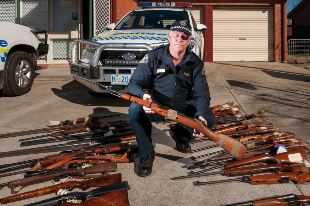 LOCKED AND LOADED: Inspector Scott Flude outside the Perth Police Station with some of the firearms surrendered as part of the weekend amnesty drive. Picture: Phillip Biggs