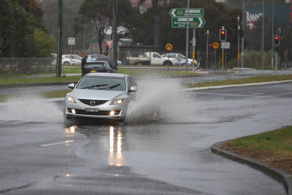 Risky: A motorist drives through water pooled across Northcliffe Drive in Warrawong. Picture: Adam McLean