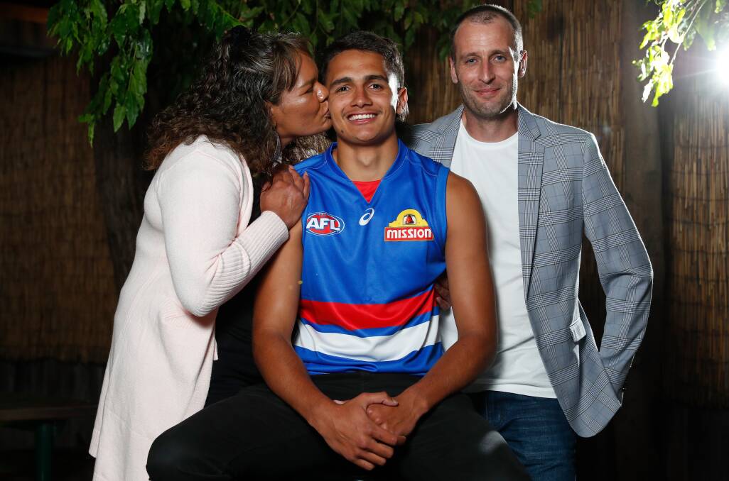 SEALED WITH A KISS: Jamarra Ugle-Hagan with mum Alice and dad Aaron after being selected at pick one in the 2020 AFL draft. Picture: Getty Images 