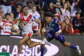 Tyrell Sloan heads for the tryline after fending off Warriors winger Dallin Watene Zelezniak at WIN Stadium on Friday night. Picture by Adam McLean