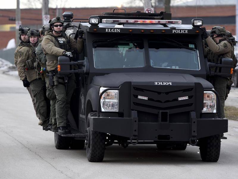 Police ride on a vehicle near the site of a shooting at a manufacturing plant in Aurora, Illinois.