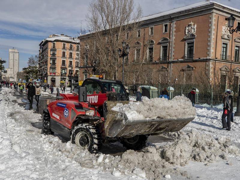 A plough clears snow in Madrid after Storm Filomena brought record snowfall and killed four people.